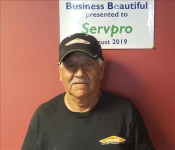 male employee in front of red wall