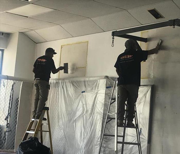 2 technicians Repairing drywall